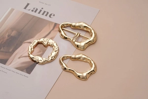 Close-up of golden irregular streamlined metal buckles and double pin belt fasteners