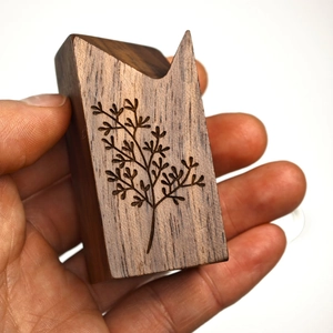 Detailed texture of black walnut brass ring holder with hand-engraved branch patterns