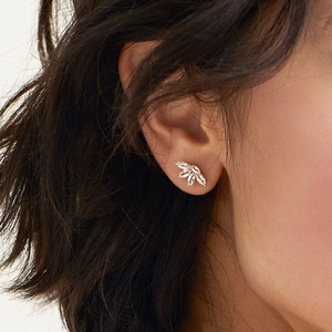 Dettaglio dell'orecchino a fiore in argento s925 con zirconi indossato da una modella