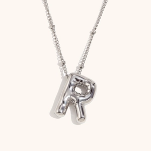 Macro detail of 3D balloon initial R pendant necklace in polished silver finish