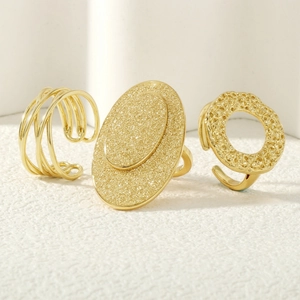 Detailed view of three gold hammered rings with hollow textured lines and matte finish