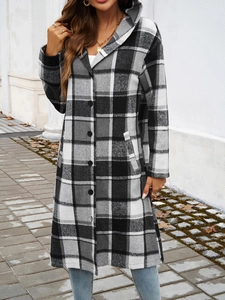 Detail of a long hooded plaid coat in black and white with buttons and side pockets