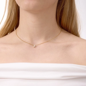 Elegante collana d'oro con ciondolo a cuore in zircone bianco indossata da una modella