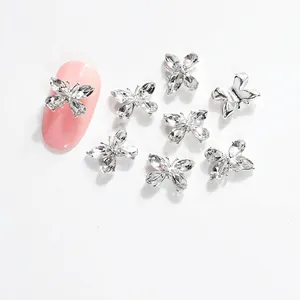 Detalle de cristales de mariposa para uñas 11x8mm con borde plateado y diamantes de vidrio K9