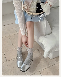 Detail of silver Mary Jane shoes with double straps and grey lace bow socks