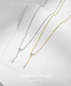 Détail de colliers en Y dorés et argentés avec pendentifs zircon sur fond minimaliste