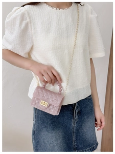 Detailed close-up of pink jelly bag featuring beaded handle, sequins, and golden turn lock