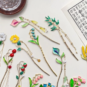Elegant traditional Chinese metal hairpins with enamel flowers and pearls on beige background
