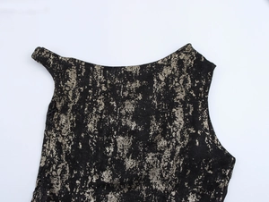 Detailed view of black fabric with metallic gold foil splatters and vintage texture