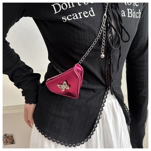Détail du mini sac triangle fuchsia avec boucle papillon argentée et bandoulière