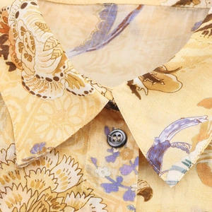Dettaglio del colletto della camicia in lino giallo a fiori con bottone nero classico