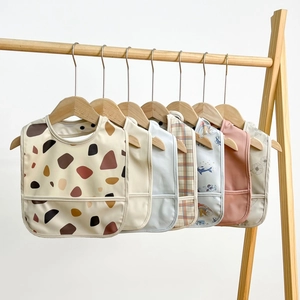 Hanging display of waterproof baby bibs set with food catcher in various cute patterns