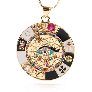 Detail of a golden coin pendant featuring a colorful evil eye and lucky symbols
