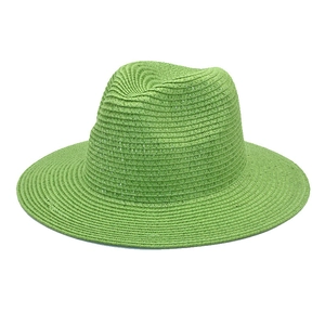 Detailed view of light green straw fedora hat featuring a natural woven texture