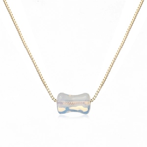 Vue détaillée d'un collier chaîne dorée avec un pendentif en pierre d'opale translucide
