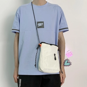 Detail of white nylon crossbody bag with orange accents and outdoor rope strap