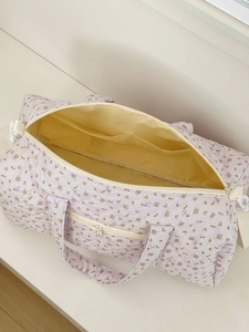 Dettaglio della borsa da viaggio trapuntata a fiori con zip e tasche interne aperte