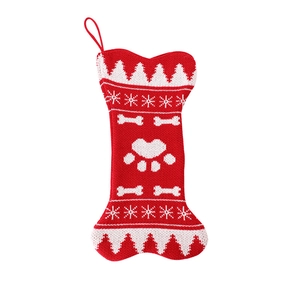 Red and white knitted bone-shaped Christmas stocking with snowflake and heart paw prints