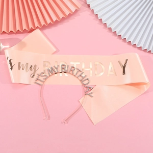 Close-up of pink satin birthday sash with rose gold lettering and rhinestone headband