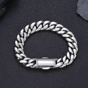 Bracelet gourmette en acier inoxydable argenté avec fermoir à ressort sur fond de roche