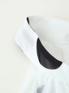 Detailaufnahme des weißen ärmellosen Polka-Dot-Tops mit atmungsaktiver Textur und Kragen
