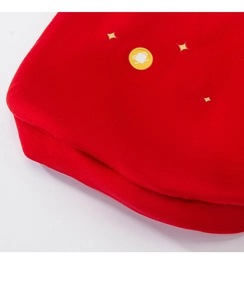 Detailed macro view of soft red festive velvet fabric with yellow star patterns for pet dogs