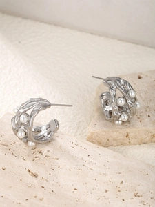 Close-up of silver C-hoop earrings with lava texture and embedded white pearls