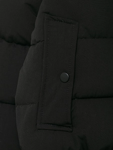 Gros plan d'une veste d'hiver noire avec texture matelassée et poche à bouton-pression