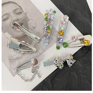 Detailed view of colorful zircon bowknot and heart hairpins on a fashion magazine background