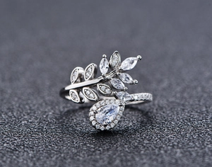 Macro view of adjustable silver ring featuring marquise leaf stones and teardrop pendant