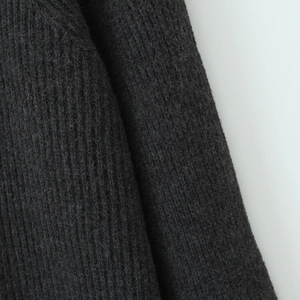 Detailed close-up of dark grey chunky knit fabric texture with vertical ribbed pattern