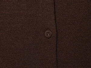 Close-up of a brown resin button on high-quality knitted fabric showing fine texture