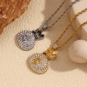 Detail of silver and gold money bag pendants with pavé crystals on twisted chains