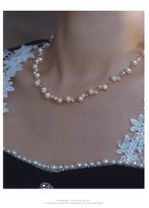 Close-up of double-layer woven pearl necklace with gold metal beads on model