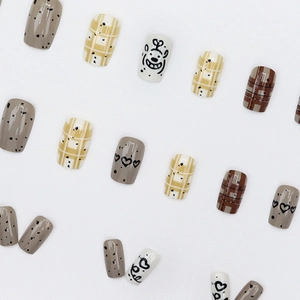 Short press-on nails set featuring brown polka dots and cute cartoon dog graffiti