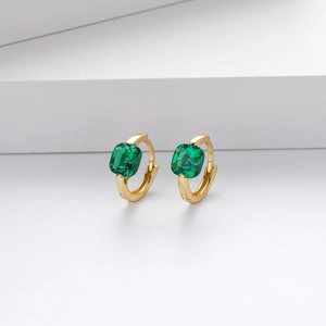 Macro shot of gold S925 sterling silver hoop earrings with square green zircon gemstones