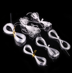 Macro detail of transparent elastic bead strings in various sizes on black background