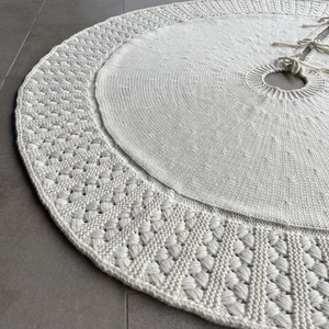 Close-up of white knitted Christmas tree skirt with popcorn stitch and textured yarn detail