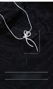 Macro view of bow ribbon necklace pendant on silver snake chain with detailed dimensions