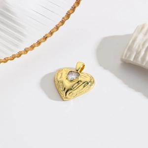 Close-up of hammered 18k gold heart pendant with sparkling center zircon stone