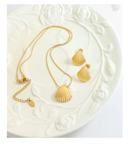 Detail of golden shell jewelry set with K18 engraving on embossed floral ceramic plate
