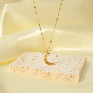 Lava moon pendant necklace with irregular hammered texture on a golden fine chain