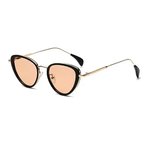 Occhiali da sole cat-eye moderni con montatura in metallo dorato e lenti arancioni sfumate