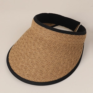 Macro detail of natural straw sun visor with intricate weave and black fabric trim