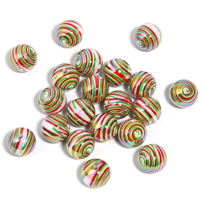Macro detail of acrylic Christmas beads with festive red, green and white swirl patterns