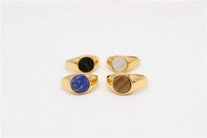 Set of four gold signet rings featuring onyx, mother of pearl, and gemstone circular inlays