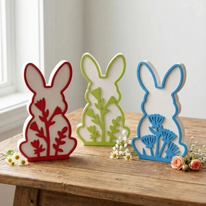 Three colorful Easter bunny wood figurines with floral patterns for spring home decor