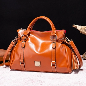 Bolso de mano vintage de cuero marrón con borlas y correa de hombro desmontable de frente