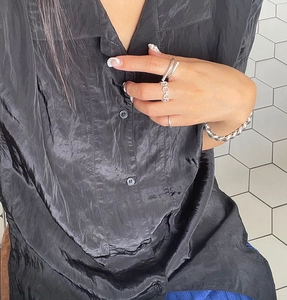 Detail showing 925 sterling silver geometric rings and bracelet with black silk shirt