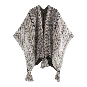 Flat lay of knit poncho with ethnic geometric patterns and tassel details in beige